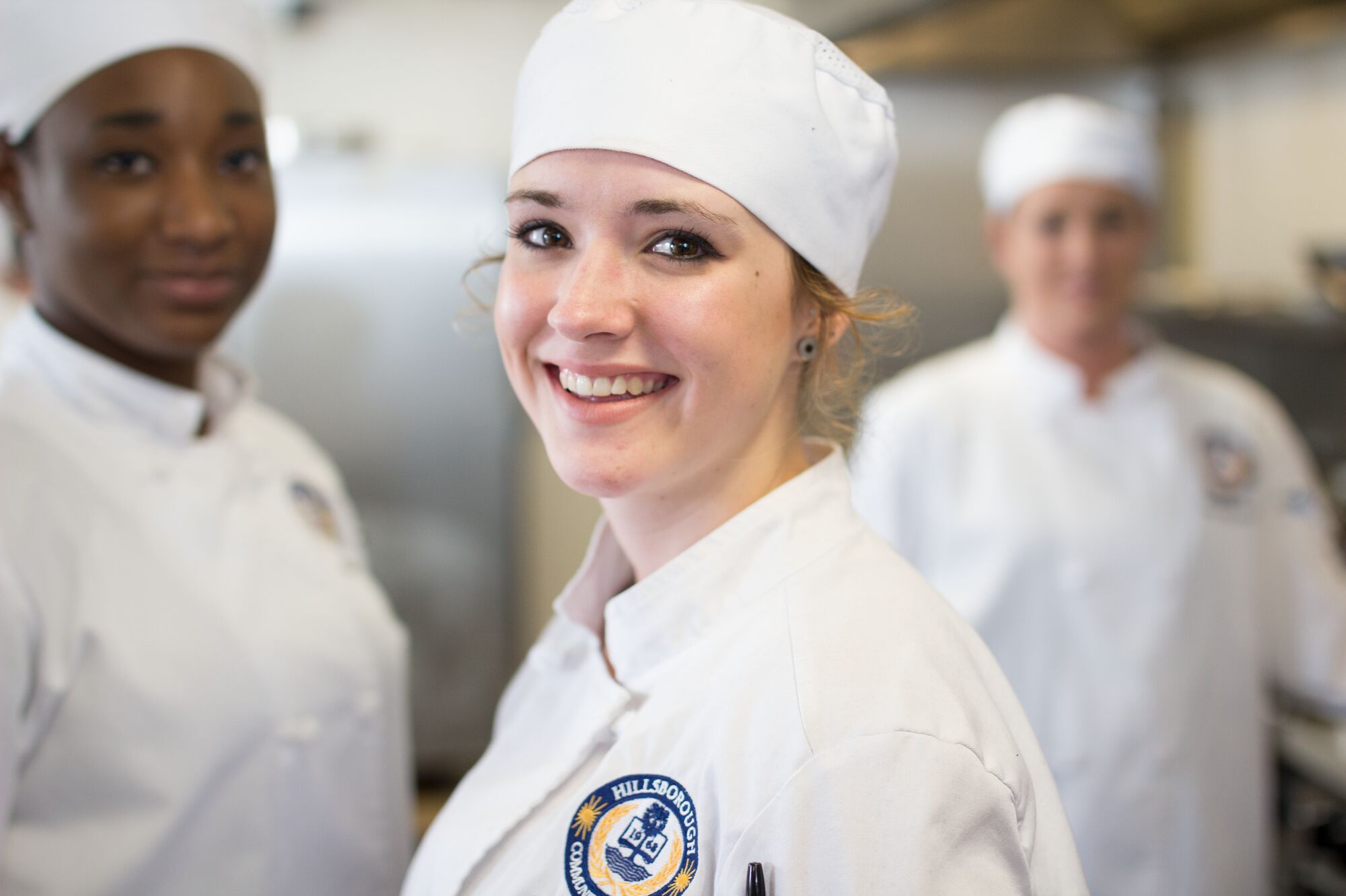 Woman in chef's toque looking at camera