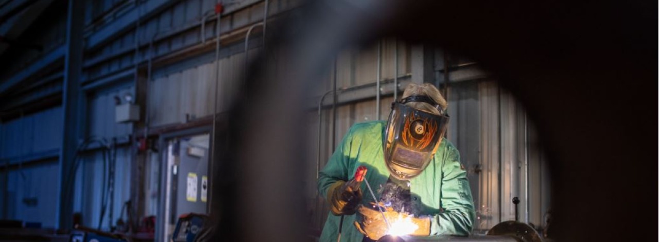 Welder working over a cylindrical object