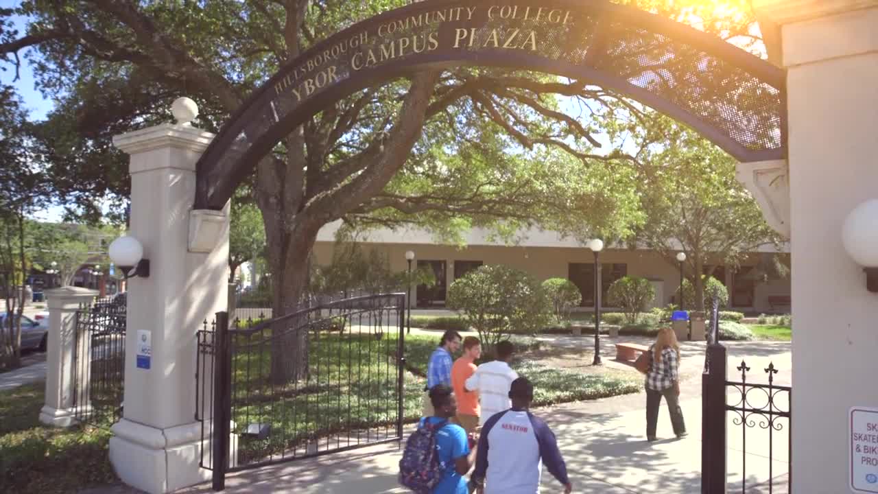 Students walking through gateway to the campus courtyard