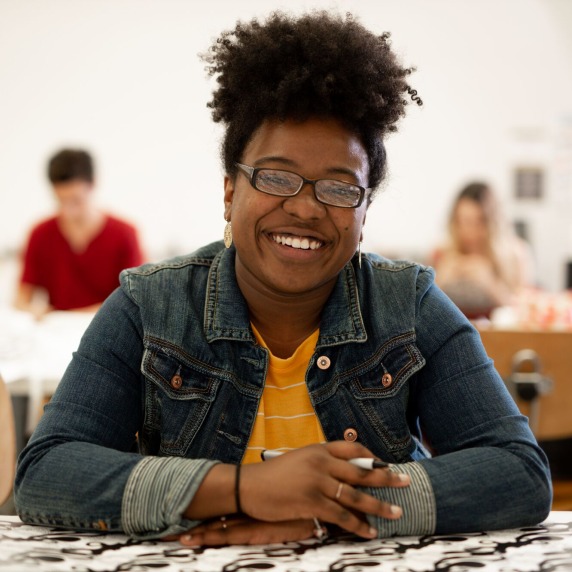 Printmaking student smiling at desk