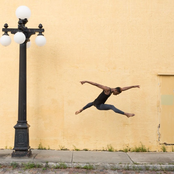 Dancer against yellow wall with lamp post