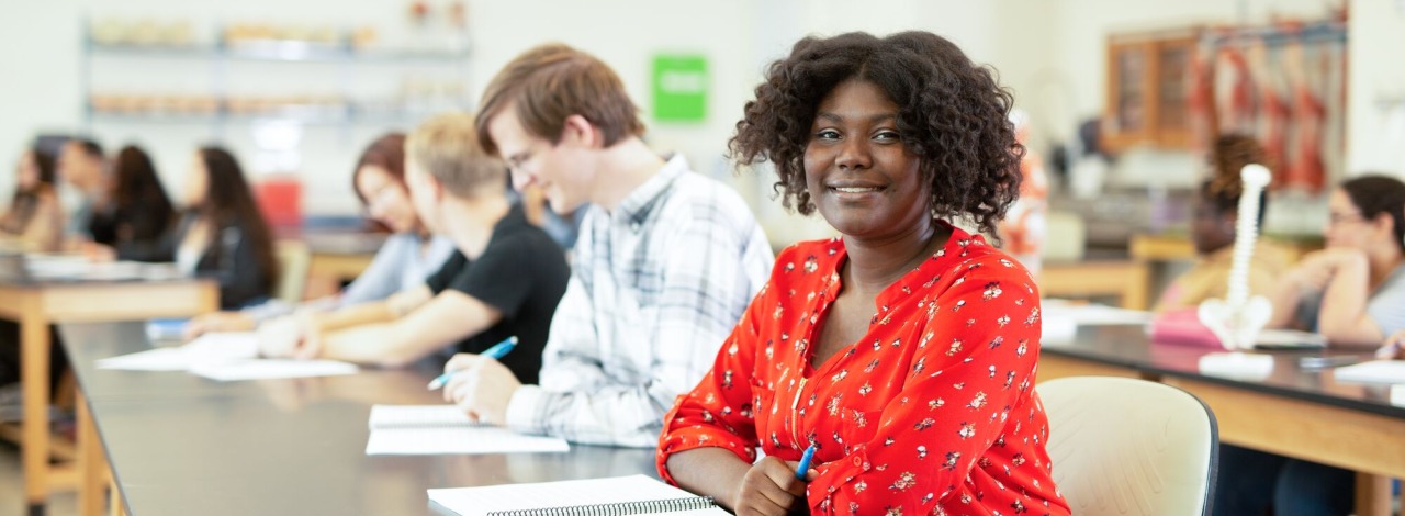 Female student smiling in a classroom during a lecture