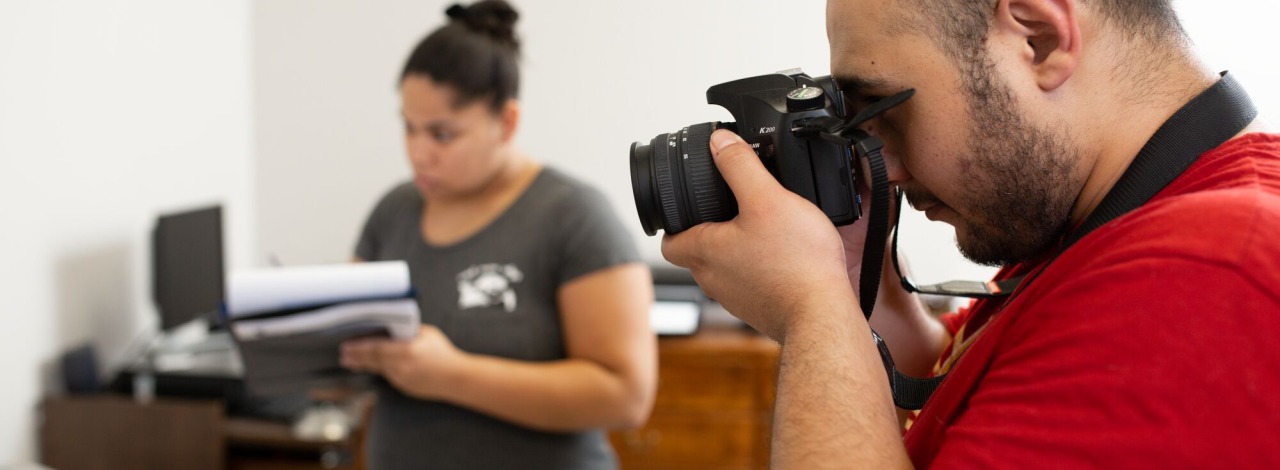 Male student photographing a mock crime scene while another student takes notes