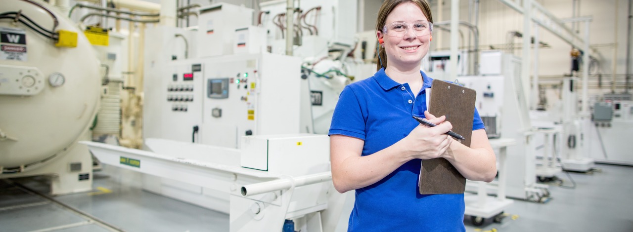 Female student wearing protective glasses in a manufacturing setting