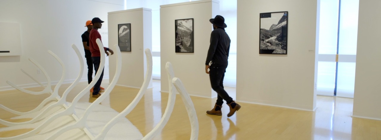 African American males walking through and enjoying an art gallery