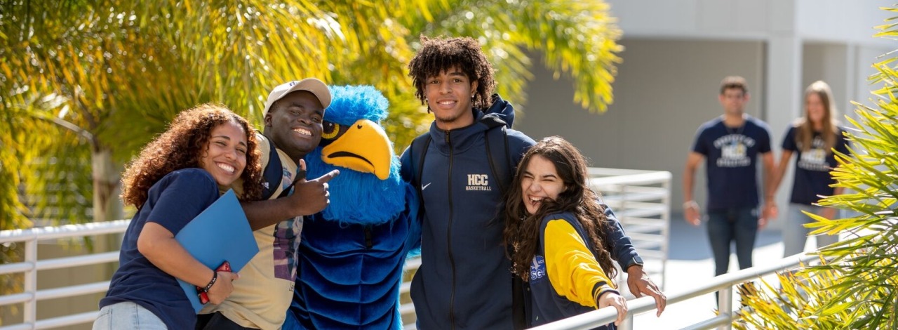 Several students on brodge with HCC hawk mascot