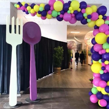 Room with giant plastic knife and fork and balloons